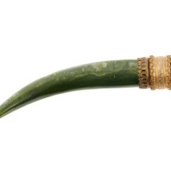 A silver-mounted jade tooth, India, 19th century, the curved tooth with a gilded silver mount and filigree decoration, attachment loop for suspension, 12.5cm. long. A Silver Mounted