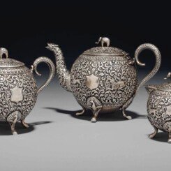 A SILVER REPOUSSÉ THREE-PIECE TEA SET
